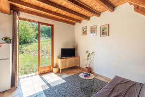 a living room with a couch and a television at Gite Lieuj in Peyrouse