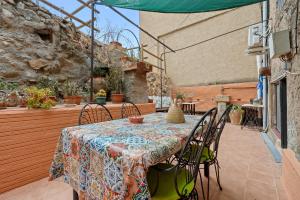 a patio with a table and chairs on a deck at Priorat Tranquil in Lloá