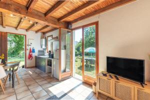 a living room with a flat screen tv and a kitchen at Gite Lieuj in Peyrouse