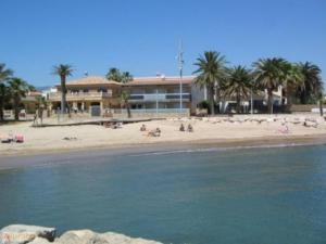 a beach with people on the sand and a building at Villa Consuelo in Cambrils