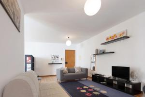 a living room with a couch and a tv at São Roque Apartment in São Roque