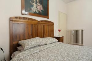 a bedroom with a bed and a painting on the wall at Appartamento Marconi 35 Pergine in Pergine Valsugana
