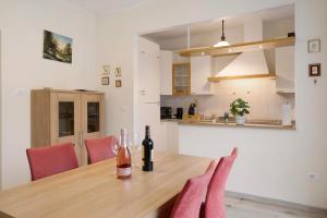 a dining room table with a bottle of wine on it at Appartamento Marconi 35 Pergine in Pergine Valsugana