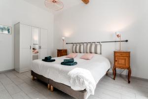 a bedroom with a large bed with pink pillows on it at Le Mas de Kitty - Maison d'hôtes in Saint-Rémy-de-Provence +64 photos