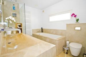 a bathroom with a tub and a toilet and a sink at Villa Blanca in Capdepera