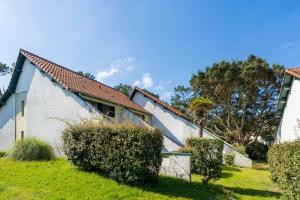 a house with a green yard with bushes at Villa Xarma, A Deux Pas de l’Océan in Seignosse