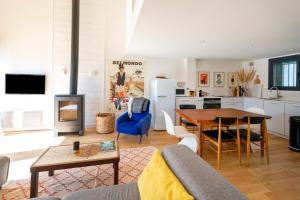 a living room with a table and a kitchen at Villa Xarma, A Deux Pas de l’Océan in Seignosse