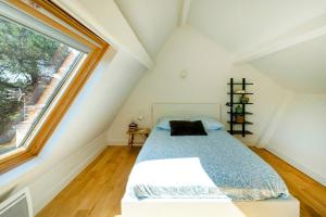 a bedroom with a bed and a large window at Villa Xarma, A Deux Pas de l’Océan in Seignosse