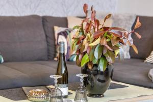 a table with a bottle of wine and a vase of flowers at Ferienwohnung, 55qm in Herscheid