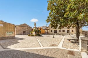 a courtyard with a tree and a building at Arbus Aventino Centrale in Arbus