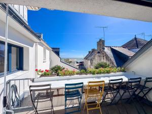 a balcony with chairs and a table with a view at Les Embruns - Vue sur mer in Île-Tudy