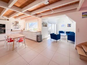 a kitchen and dining room with a table and chairs at Les Embruns - Vue sur mer in Île-Tudy