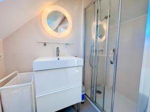 a bathroom with a sink and a shower at Les Embruns - Vue sur mer in Île-Tudy +29 photos