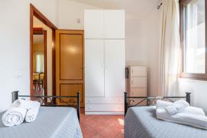 a bedroom with two beds and a window at Casa Mameli in Quartucciu