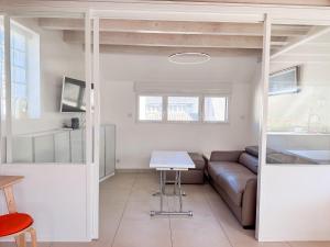 a living room with a couch and a table at Les Embruns - Vue sur mer in Île-Tudy