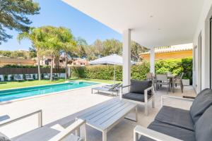 a patio with a pool and chairs and a table at The Tower Villa in El Toro