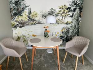 a table with two chairs and a vase with flowers at Herzlichstharz - Klein und Fein in Bad Lauterberg