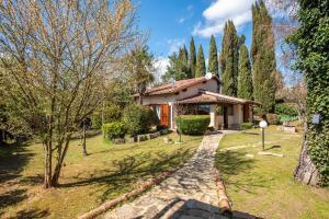 a house in a garden with a path leading to it at Antiche Dimore Del Vescovado in Siena
