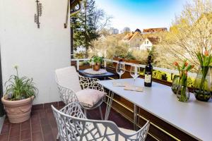 a balcony with a table and chairs and wine glasses at Herzlichstharz - Klein und Fein in Bad Lauterberg