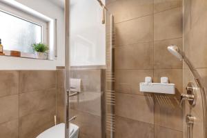 a bathroom with a toilet and a glass shower at Ferienwohnung Emilia, 36qm in Münsingen