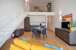 a living room with a yellow couch and a table and a staircase at Sogno di Mare in Bari