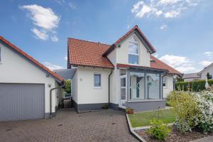 a white house with a red roof at Ferienwohnung Emilia, 36qm in Münsingen