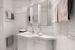 a white bathroom with a sink and a mirror at Ferienwohnung am Schlosssee in Salem +10 photos