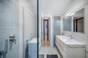 a white bathroom with a sink and a mirror at La terrazza sul faro in Lignano Sabbiadoro +22 photos