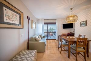 a living room with a couch and a table and a dining room at La terrazza sul faro in Lignano Sabbiadoro