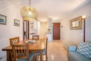 a dining room and living room with a table and a couch at La terrazza sul faro in Lignano Sabbiadoro