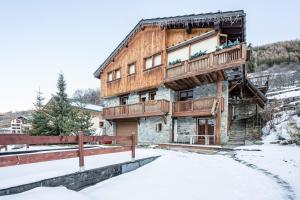 a wooden building with a balcony in the snow at Appartement Génépi dans Chalet 14p in Praranger