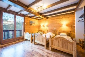 a bedroom with two beds in a room with wooden walls at Appartement Génépi dans Chalet 14p in Praranger