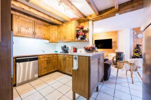 a kitchen with wooden cabinets and a counter top at Appartement Génépi dans Chalet 14p in Praranger