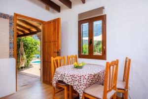 a dining room with a table and chairs and a door at Villa Frontera in Sóller