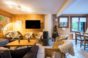 a living room with couches and a table and a television at Appartement Génépi dans Chalet 14p in Praranger
