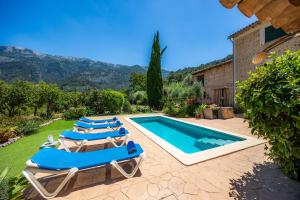 a villa with a swimming pool and lounge chairs at Villa Frontera in Sóller