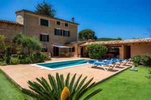 a villa with a swimming pool in front of a house at Villa Frontera in Sóller