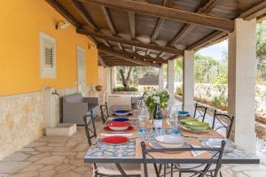 a table with chairs and plates on a patio at Villa Bartolomeo in Modica