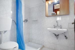 a bathroom with a toilet and a sink and a mirror at Areti Orfeas Apartment 5 in Vasilikos