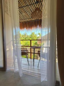 a room with a balcony with a table and chairs at Laya Boutique Hotel in General Luna