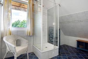 a bathroom with a shower and a chair in it at Landhaus Peenemünde in Peenemünde +13 photos