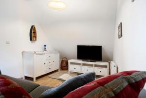 a living room with a couch and a flat screen tv at Landhaus Peenemünde in Peenemünde