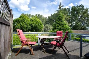 three chairs and a table on a balcony at Landhaus Peenemünde in Peenemünde