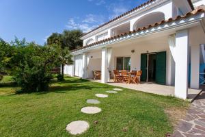 a backyard of a white house with a patio at Villa Mula 1 in Orosei