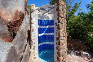 a pool with blue tiles on the side of a building at Villa Mula 1 in Orosei