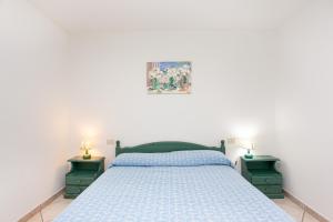 a bedroom with a blue bed and two night stands at Villa Mula 1 in Orosei