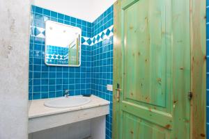 a blue tiled bathroom with a sink and a mirror at Villa Mula 1 in Orosei +19 photos