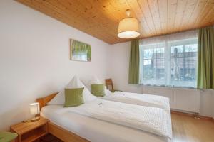 a bedroom with a white bed and a window at Baschijörgenhof in Sankt Peter