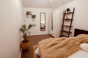 a bedroom with white walls and a bed with a blanket at Apartment in cite center in Manchester