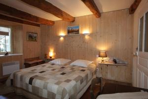 a bedroom with a bed in a room with wooden walls at le clos saint François in Beaune-sur-Arzon